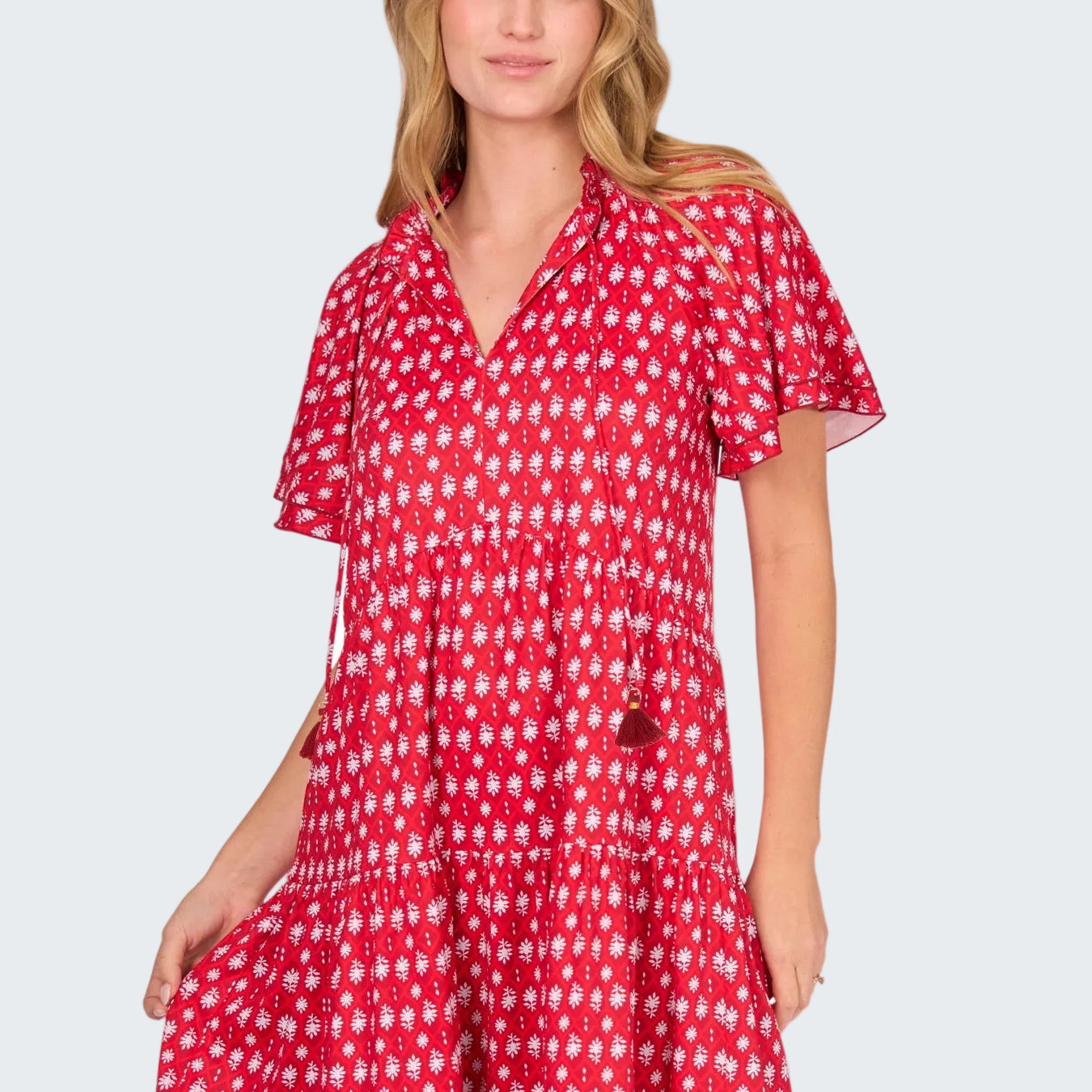 Woman wearing a red and white patterned dress on a white background