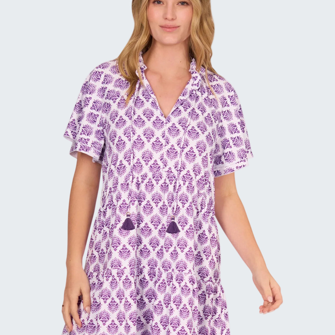 Woman wearing a purple patterned dress on a white background