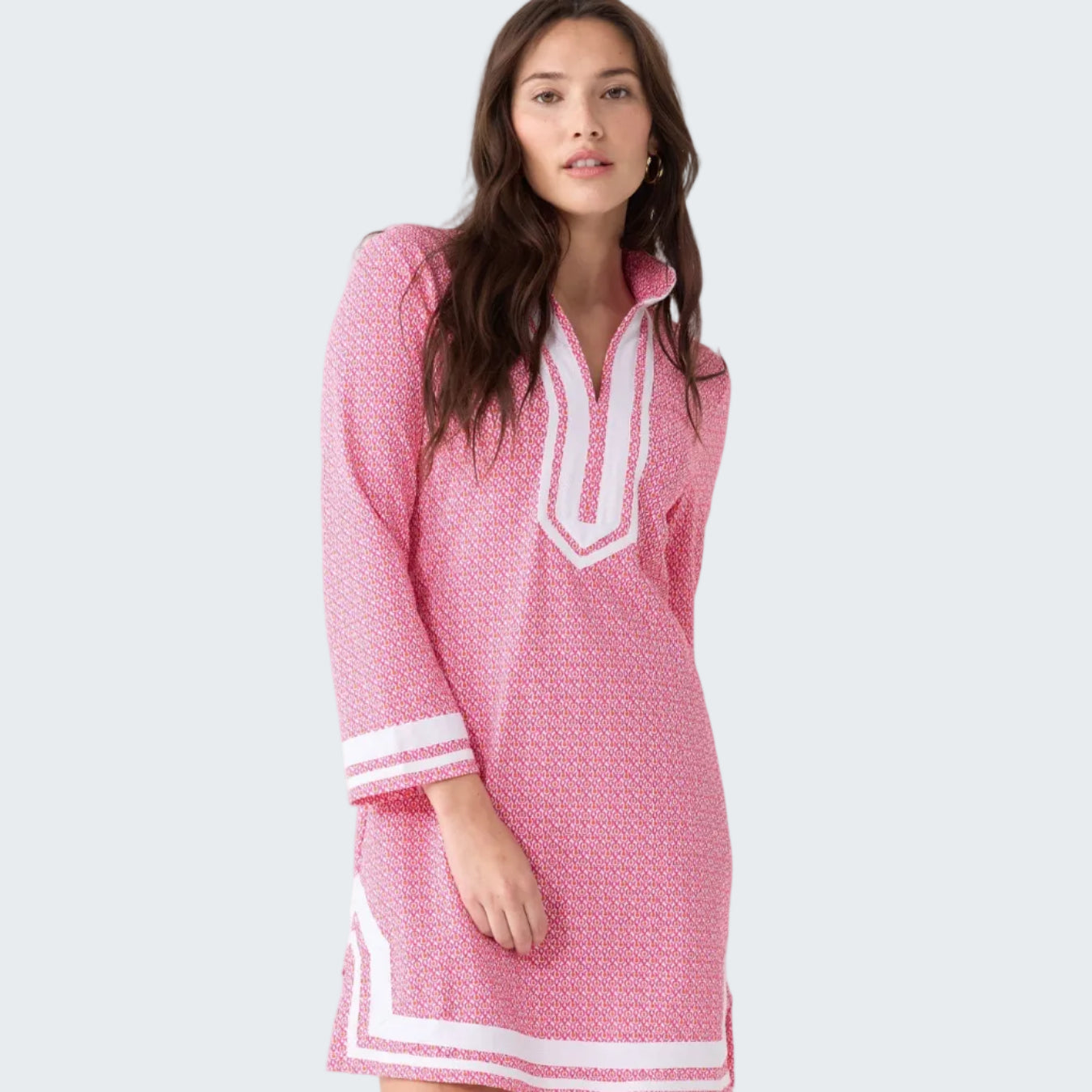 Woman wearing a pink dress with white accents on a white background