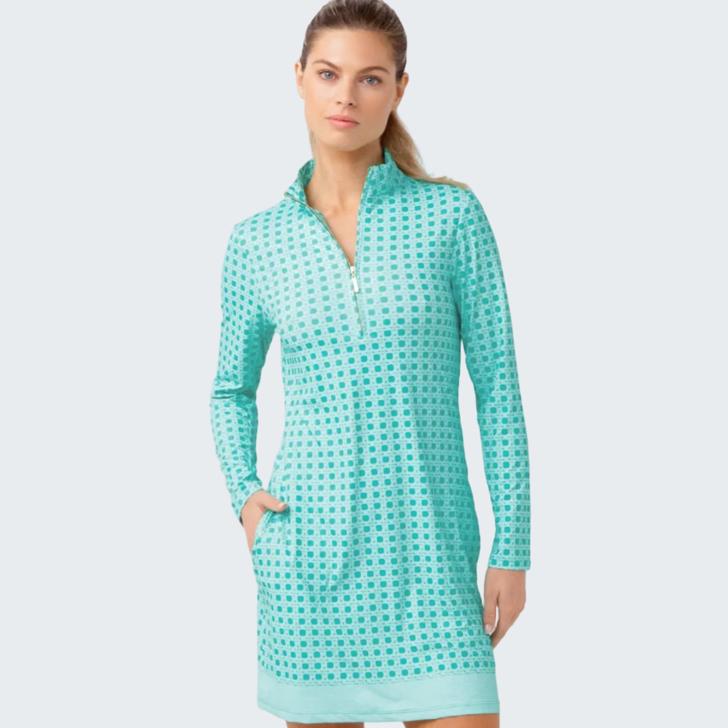Woman wearing a teal checkered dress against a light gray background