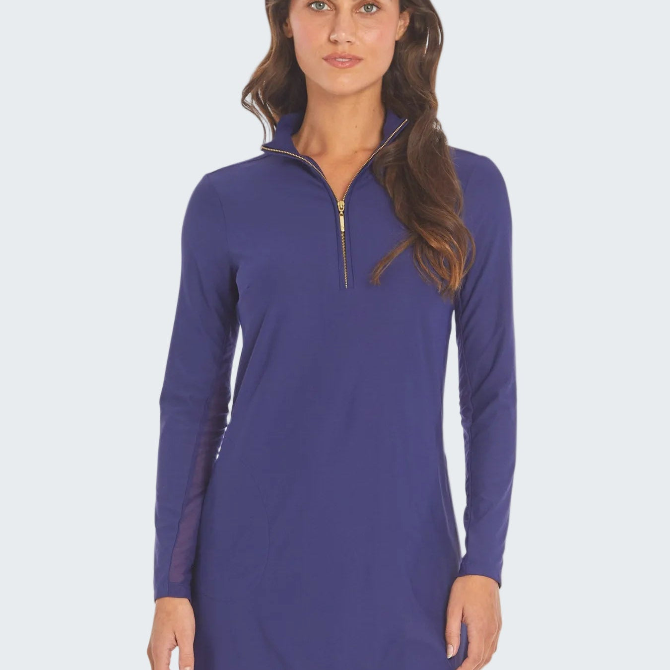 Woman wearing a purple long-sleeve dress with a quarter zip on a white background