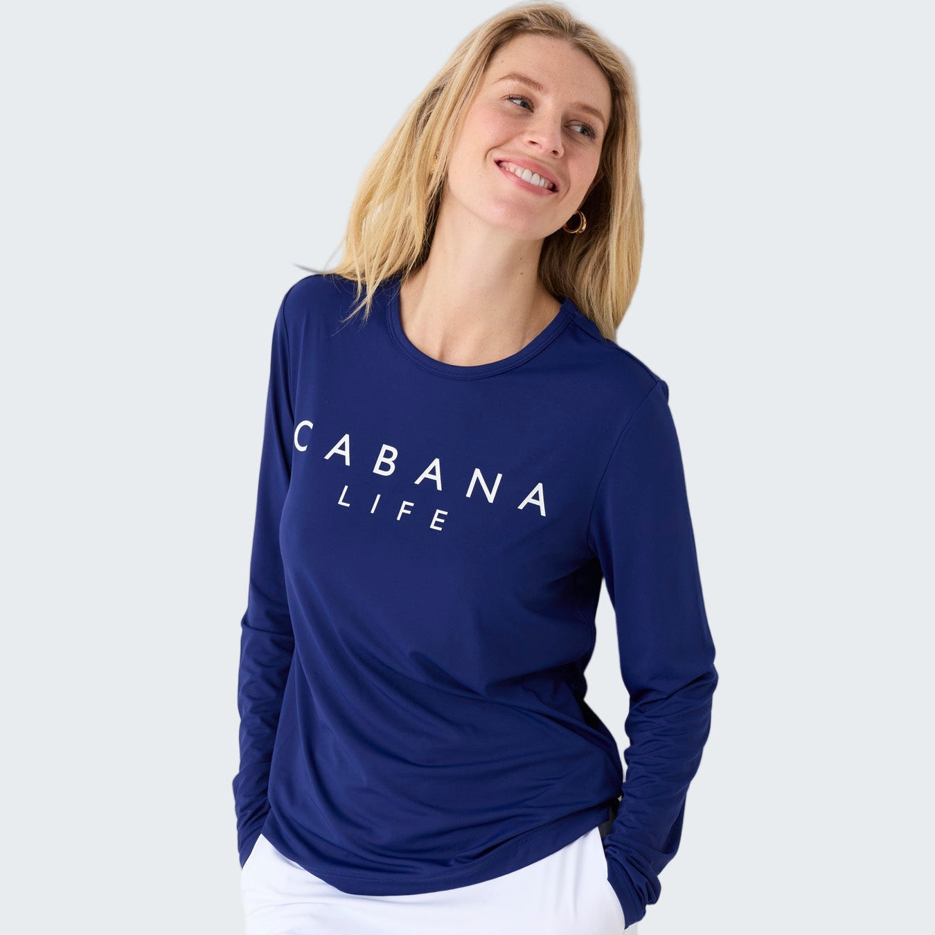 Woman wearing a blue 'Cabana Life' shirt and white skirt on a white background