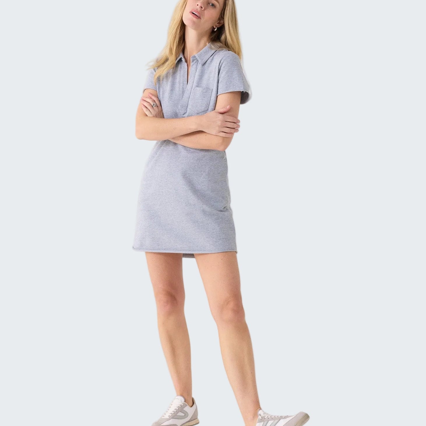 Woman wearing a light blue dress standing against a white background