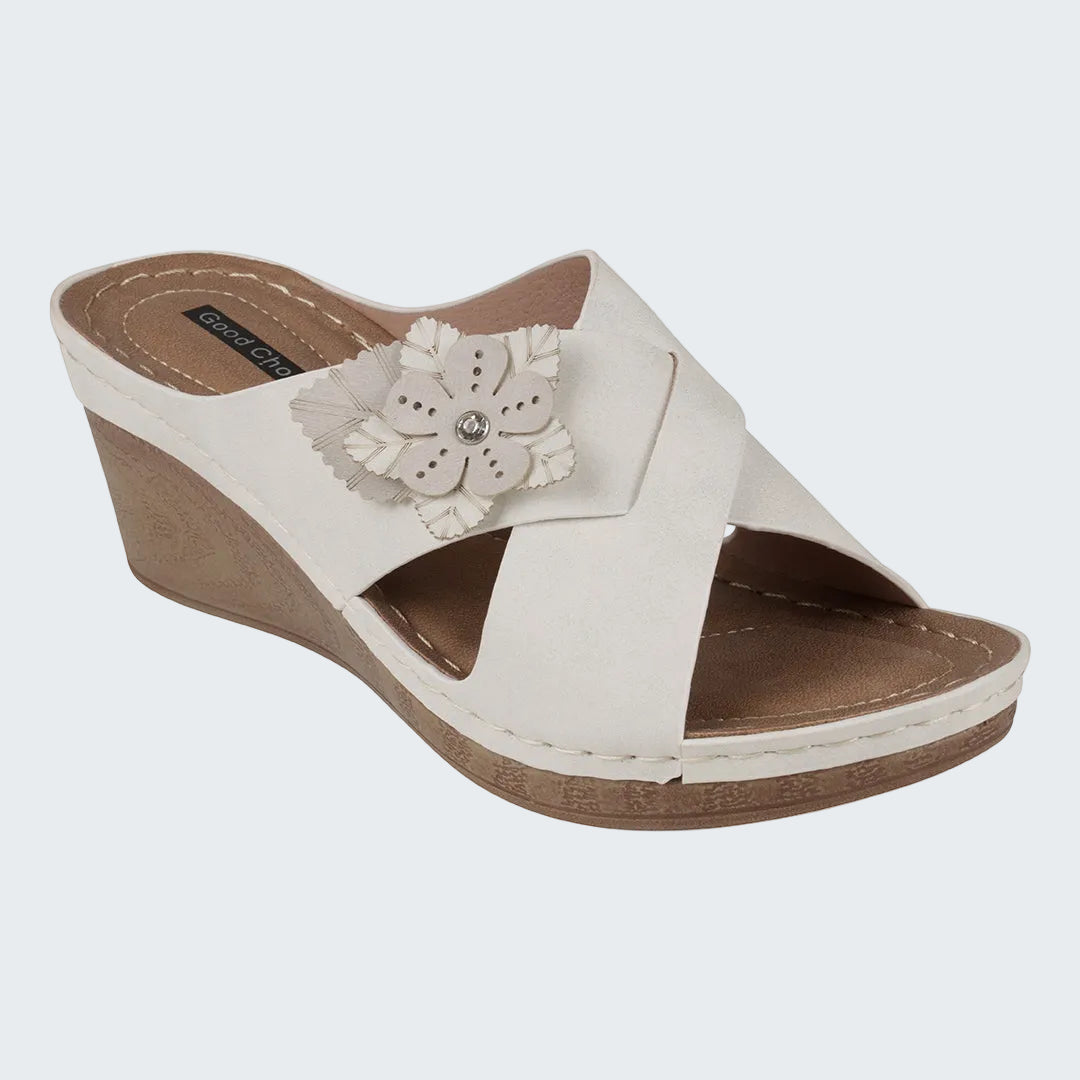 White wedge sandal with a decorative flower on a white background