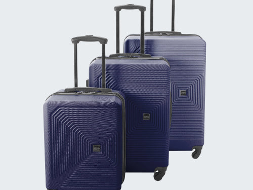 Set of three blue suitcases with geometric patterns on a white background