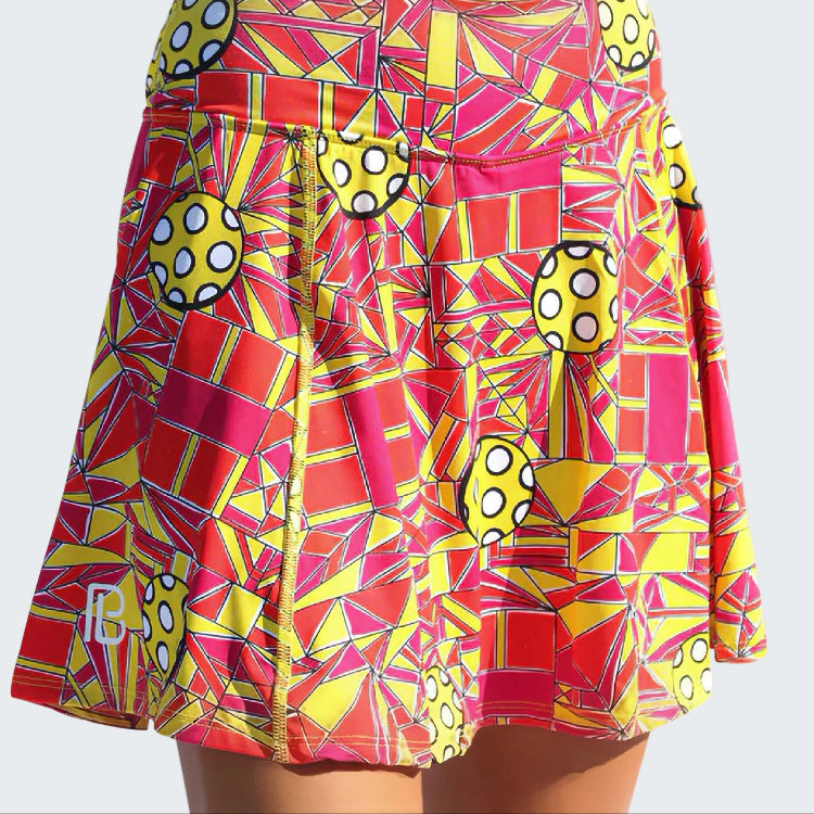 Colorful geometric patterned skirt with polka dot accents on a white background