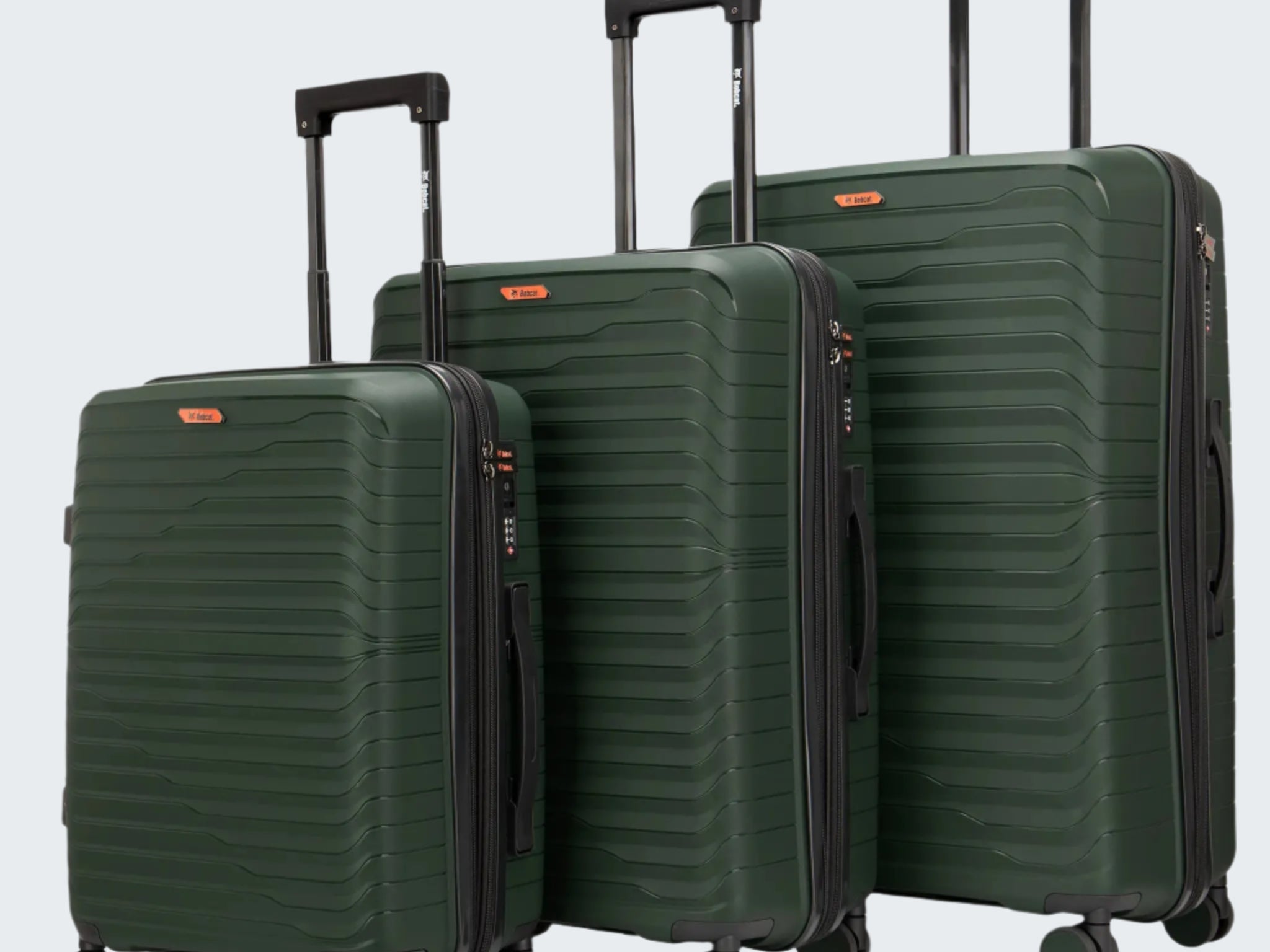 Set of three green suitcases of different sizes on a white background