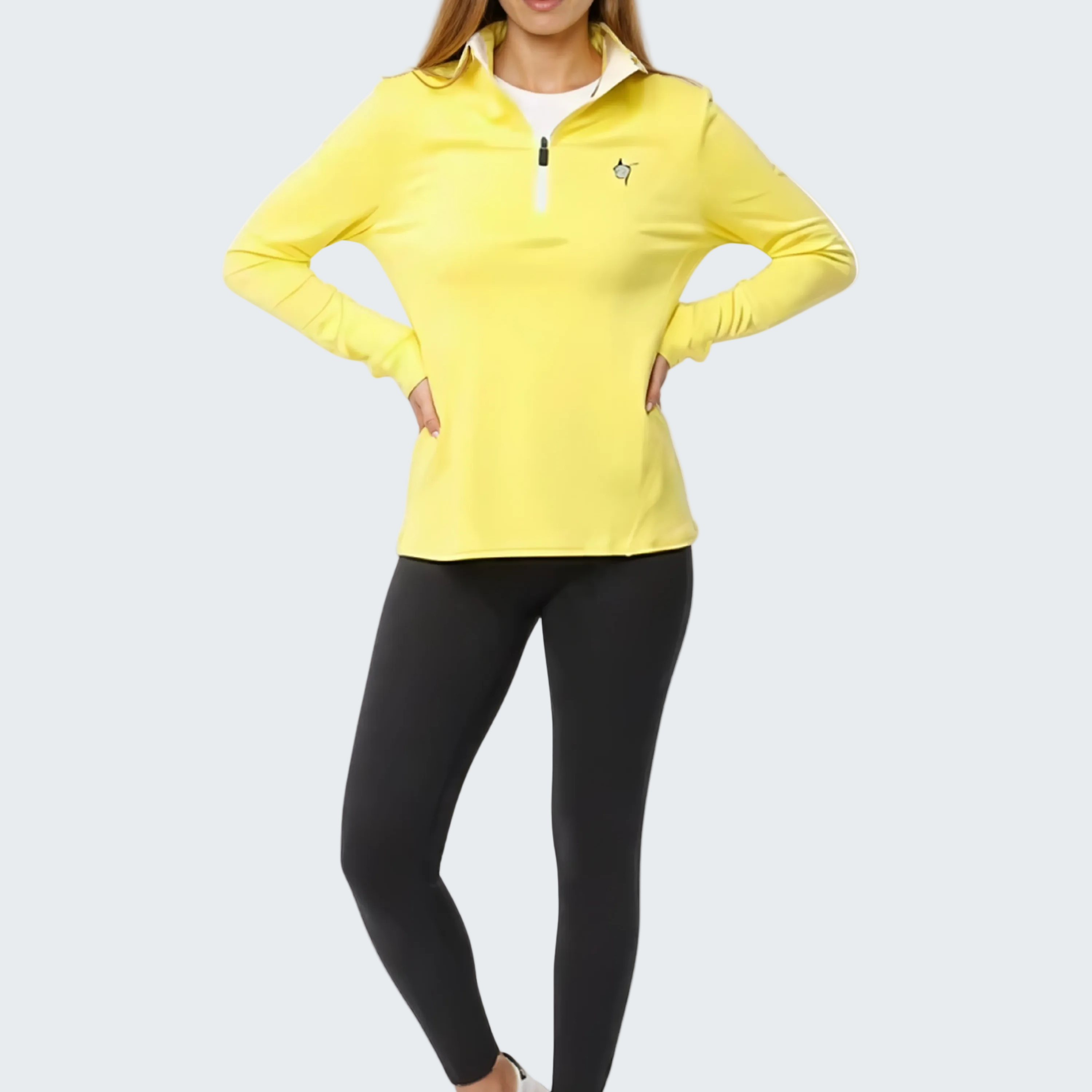 Woman wearing a yellow long-sleeve top and black leggings on a white background