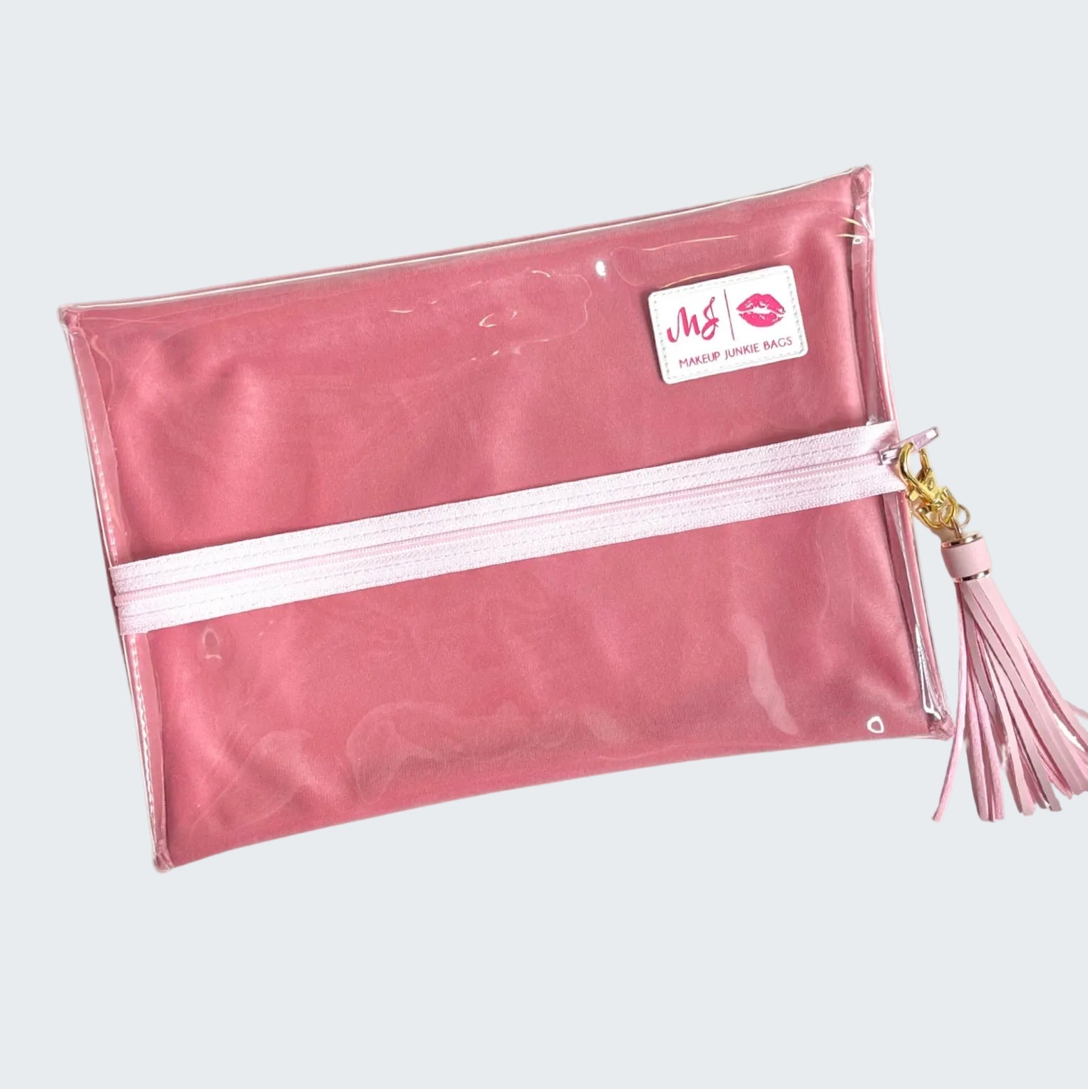 Pink makeup bag with a tassel on a white background