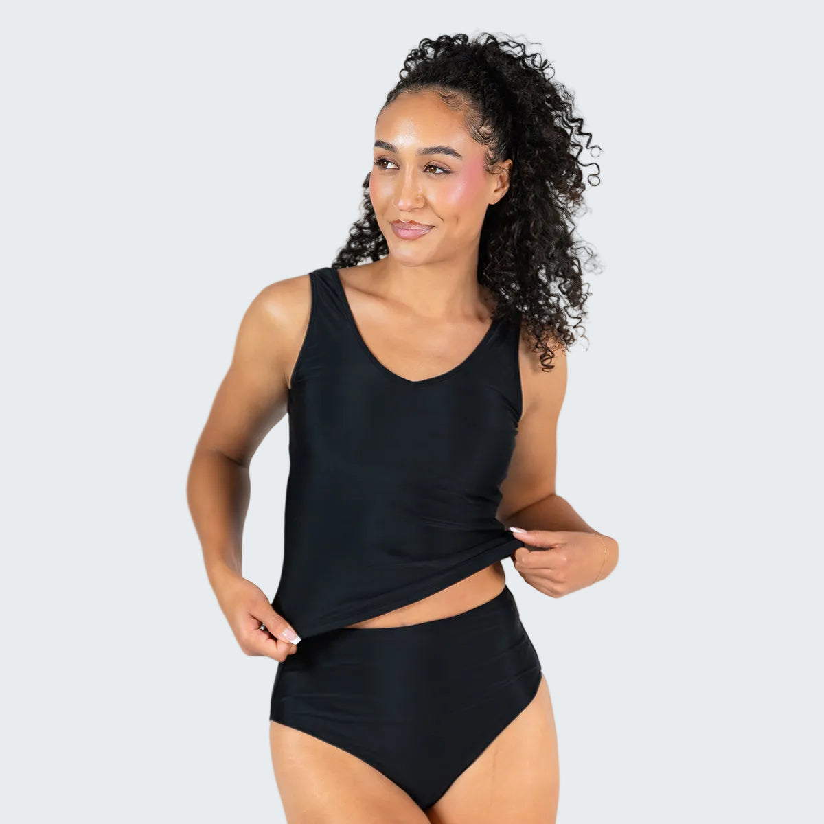 Woman wearing a black tankini set on a white background