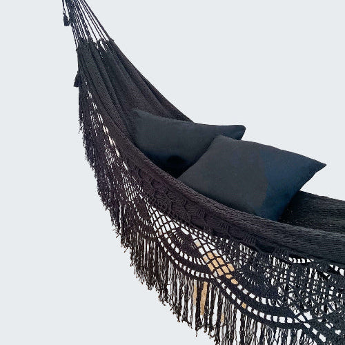 Black hammock with pillows in a room with decorative elements