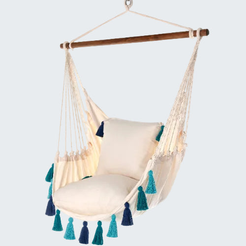 Beige hammock chair with blue and green tassels on a white background