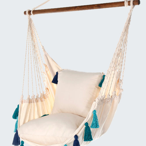 Beige hammock chair with blue and green tassels on a white background