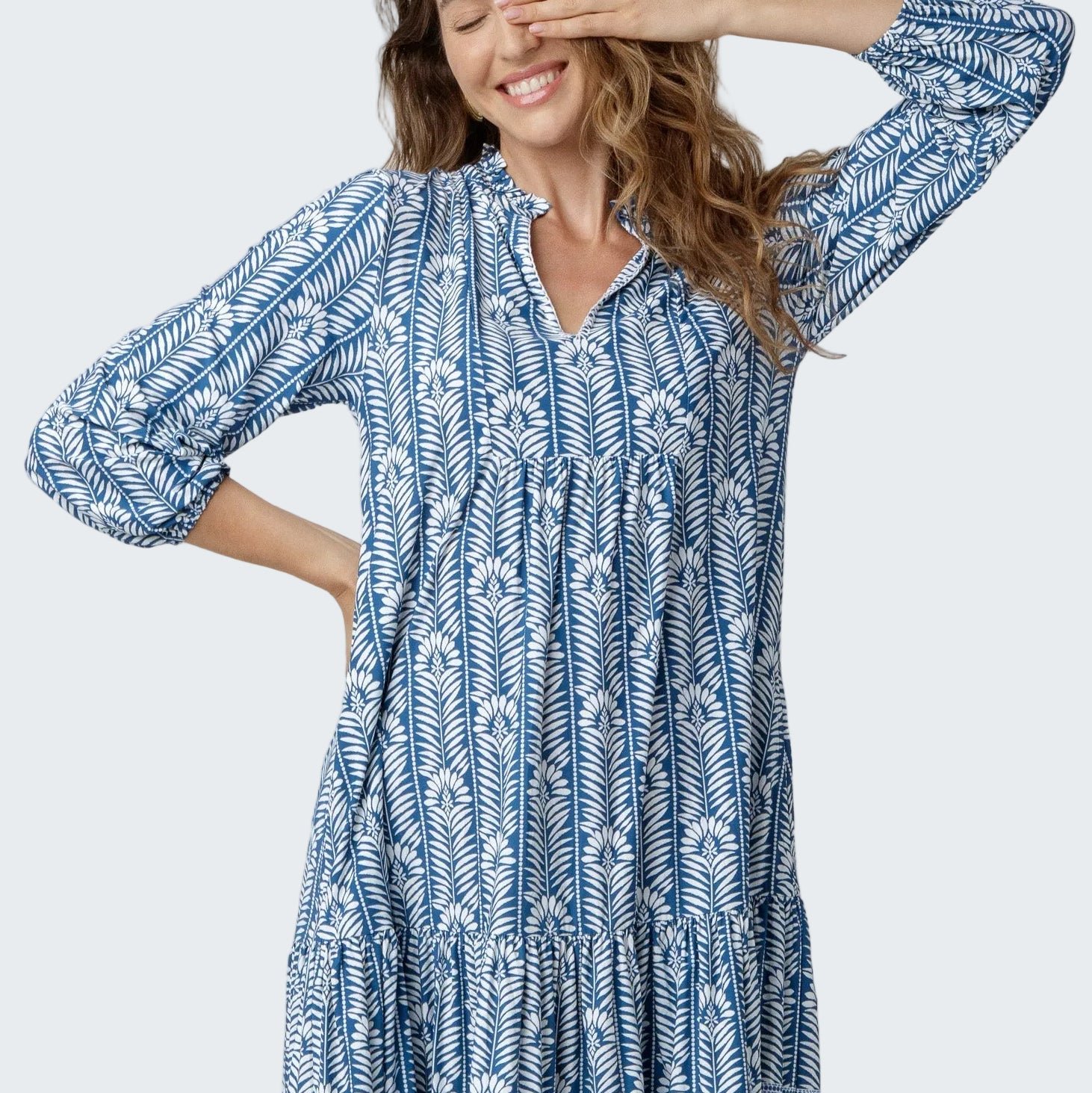 Woman wearing a blue and white patterned dress on a white background
