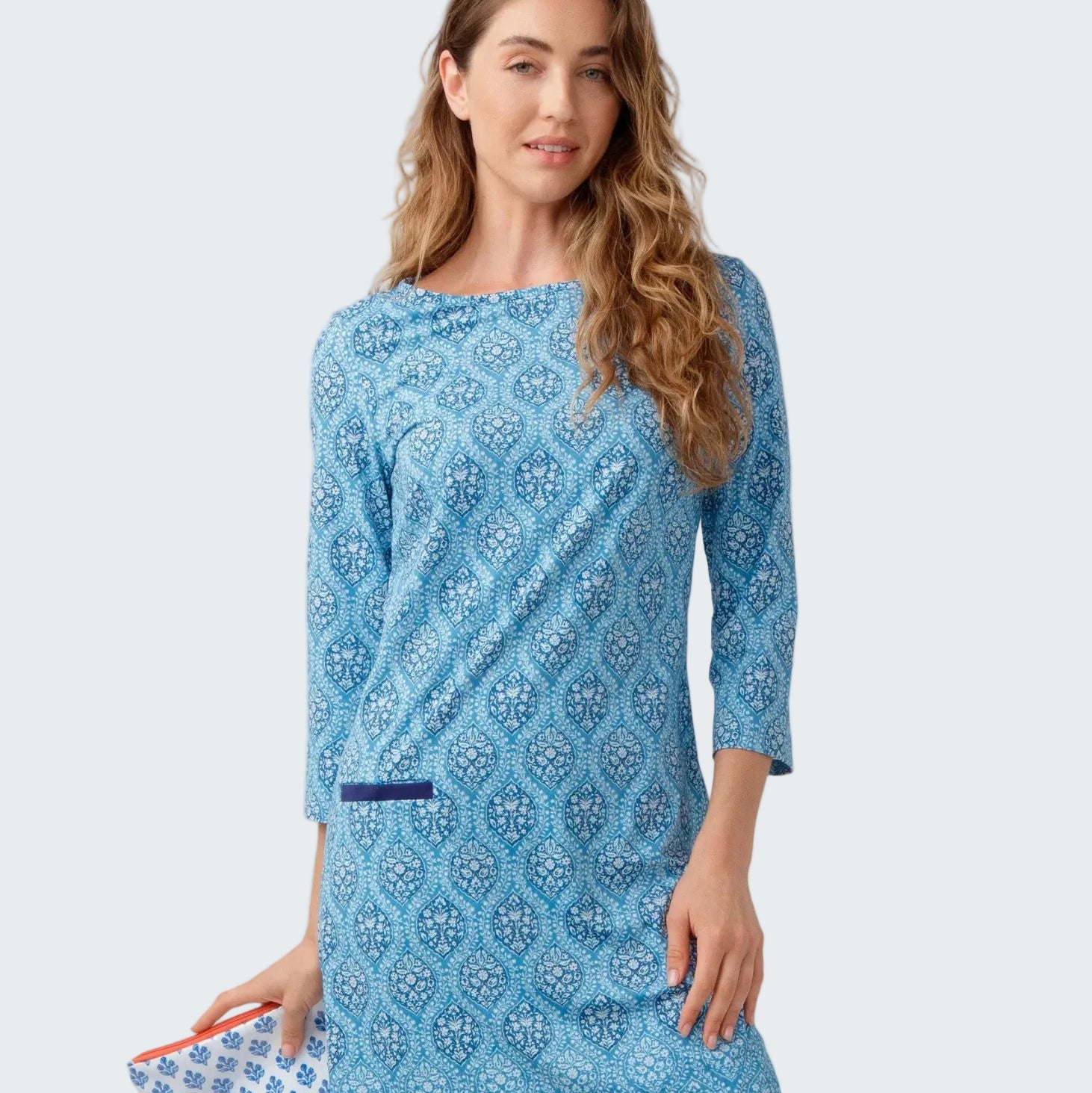 Woman wearing a blue patterned dress on a white background