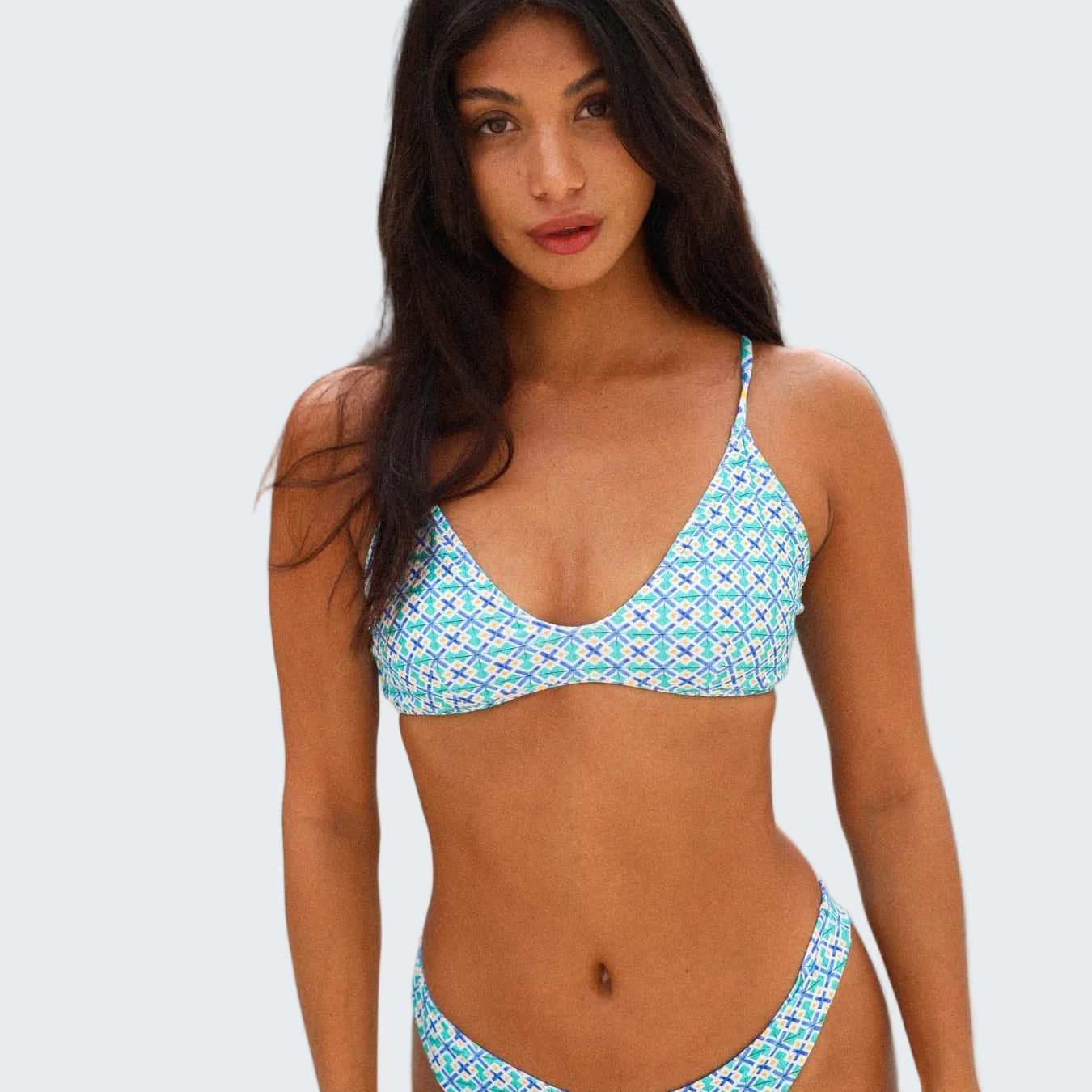 Woman wearing a blue patterned bikini by a pool