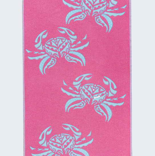 Pink towel with blue crab patterns on a white background