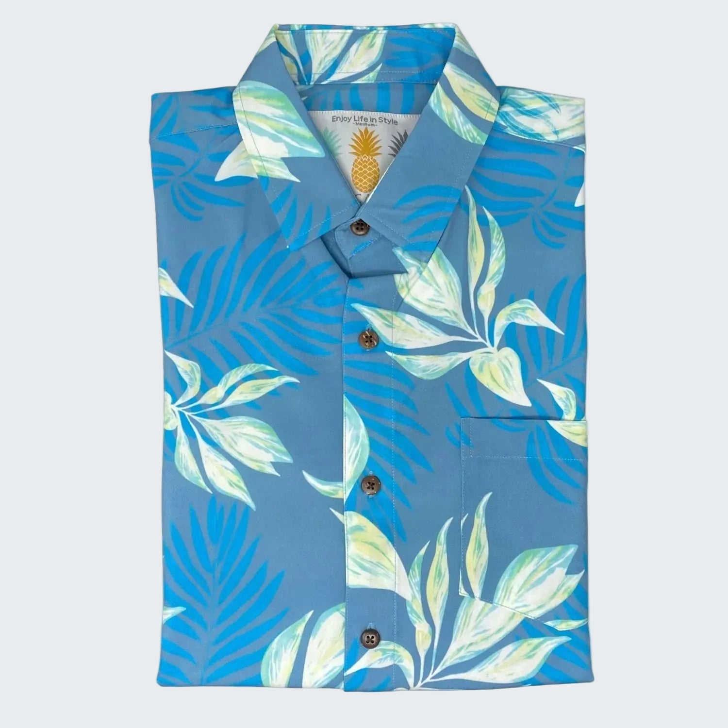 Folded blue shirt with tropical leaf pattern on a white background