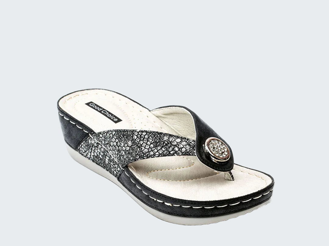 Black and white sandal with a decorative strap on a white background