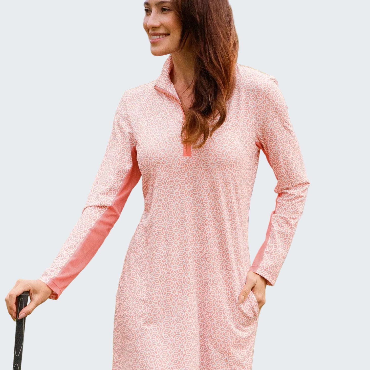 Woman in a pink dress standing on a golf course