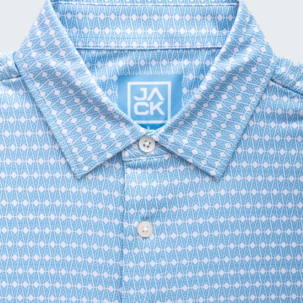 Close-up of a blue patterned shirt with a brand label on a white background