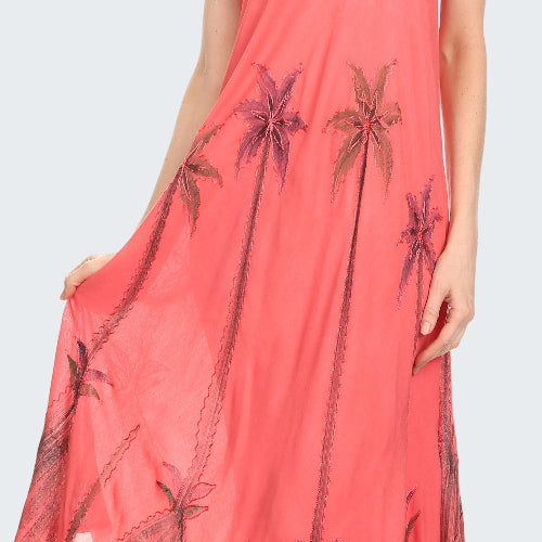 Coral dress with palm tree pattern worn by a model on a white background