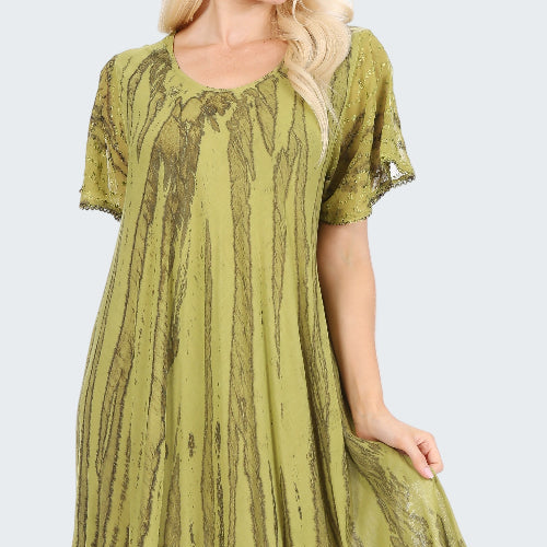 Green patterned dress worn by a model on a white background