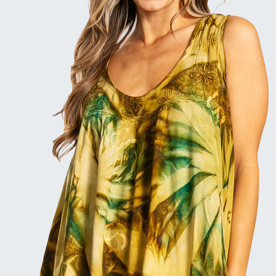 Woman wearing a yellow and green floral dress on a white background