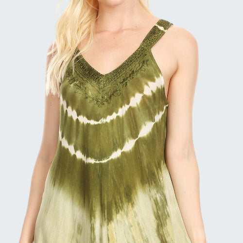 Woman wearing a tie-dye dress with green and white pattern on a plain background