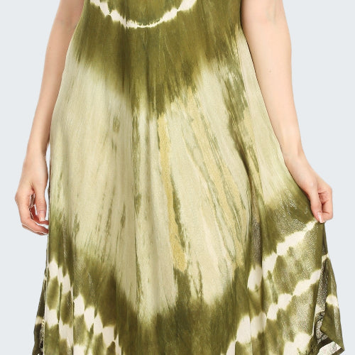 Woman wearing a tie-dye dress with green and white pattern on a plain background