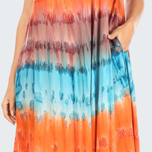 Woman wearing a tie-dye dress with orange, blue, and pink colors.