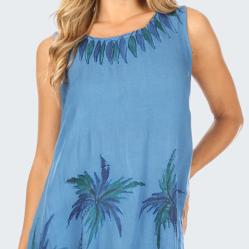 Blue dress with palm tree pattern worn by a model on a white background
