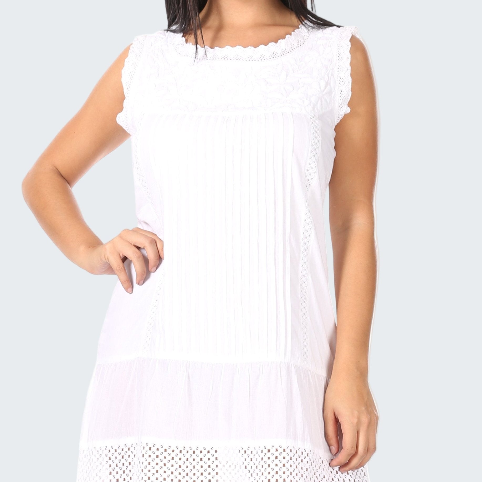 White sleeveless dress with lace details on a white background