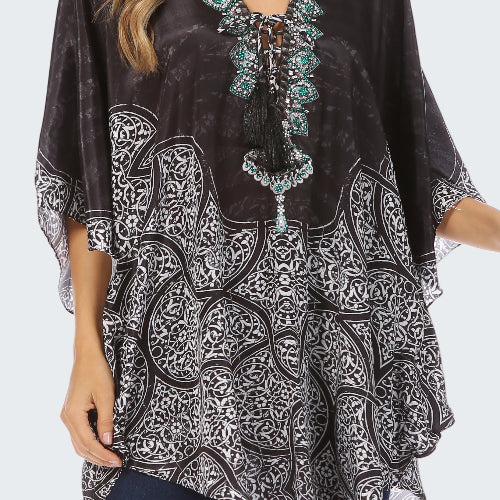 Black patterned top with turquoise embellishments worn by a model on a white background