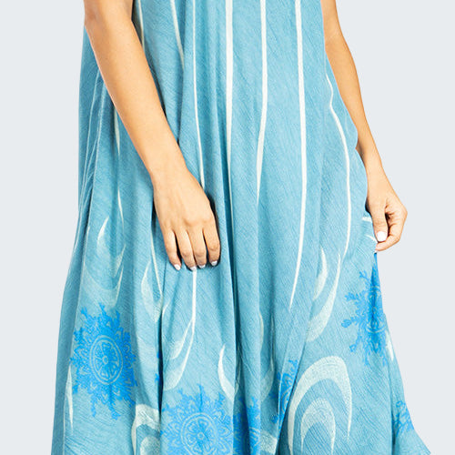 Woman wearing a blue sleeveless dress with white patterns on a white background