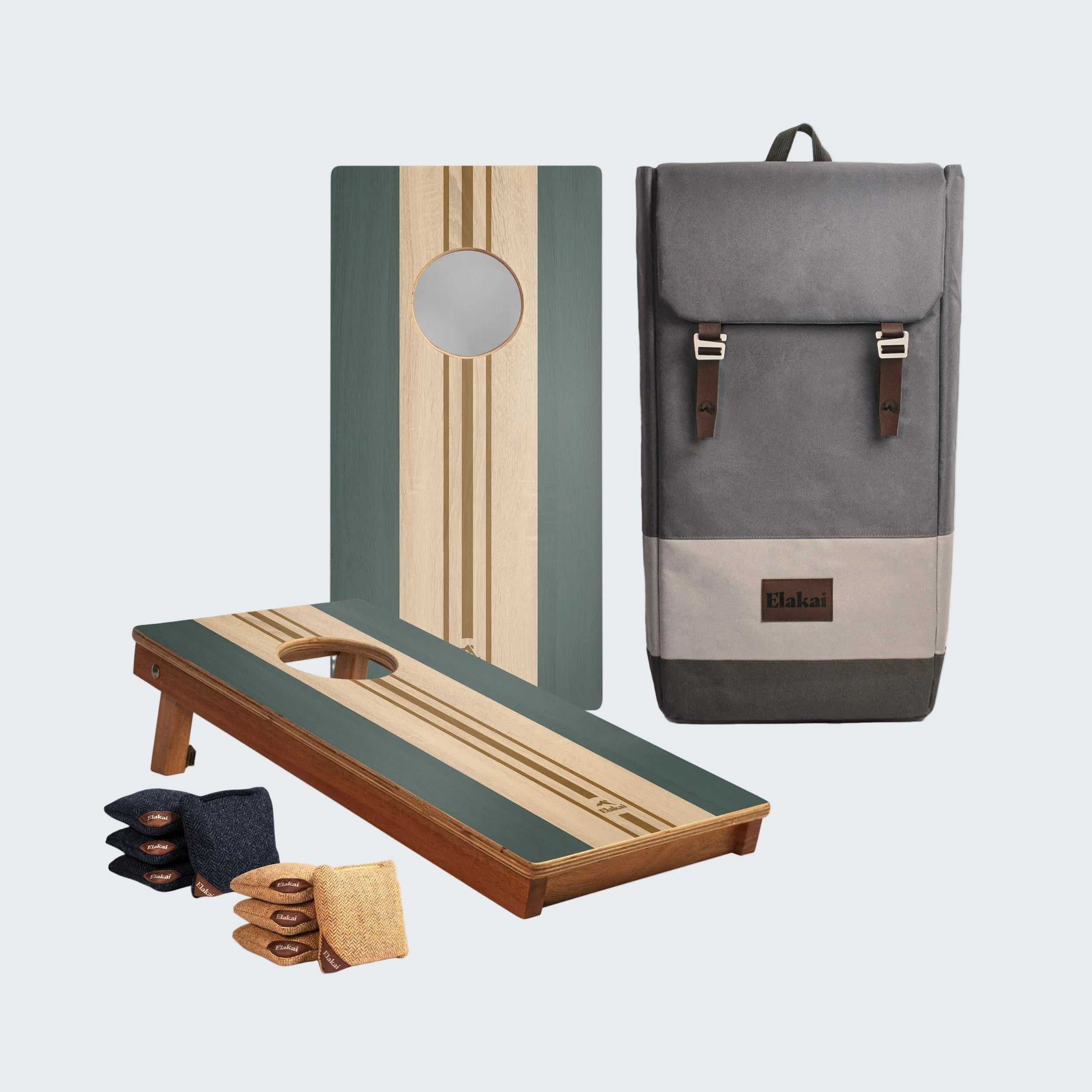 A cornhole set displayed on a white background, including a wooden game board, a matching backboard, a gray fabric storage bag with brown leather straps, bean bags, and bean bags with wooden handles.