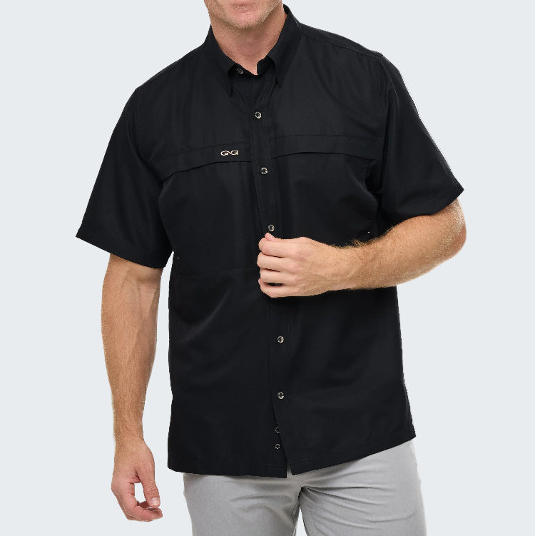 Man wearing a black short-sleeve shirt with a brand logo on a white background
