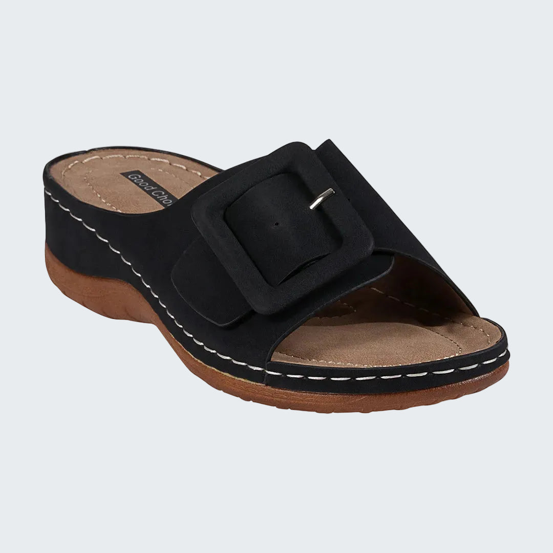Black sandal with a brown sole on a white background