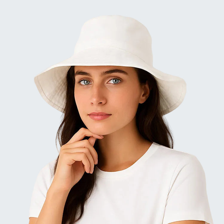 Woman wearing a white hat and white shirt against a light background