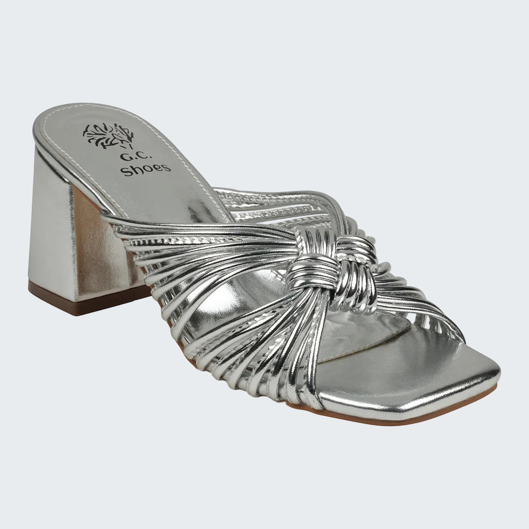 Silver high-heeled shoe with a bow design on a white background