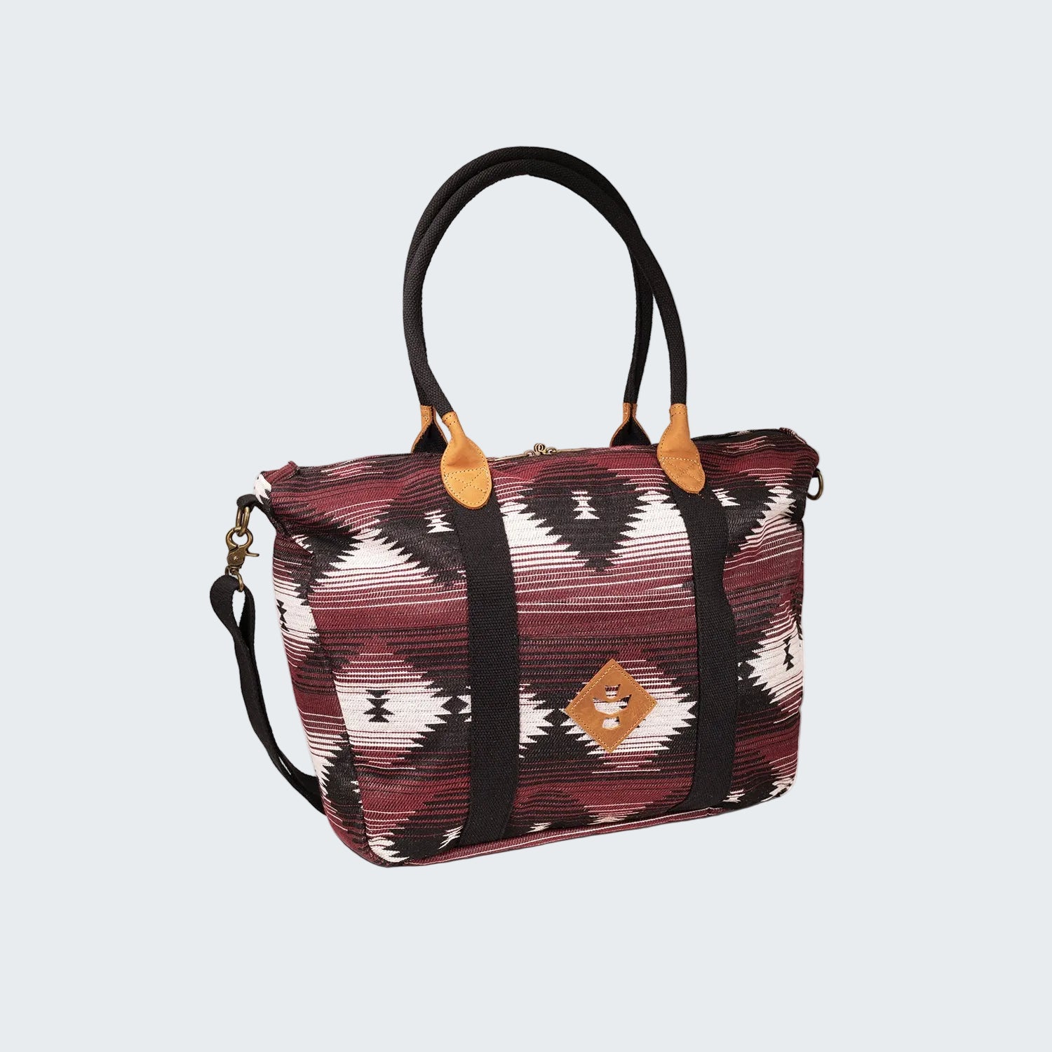 Patterned handbag with black handle and strap on a white background