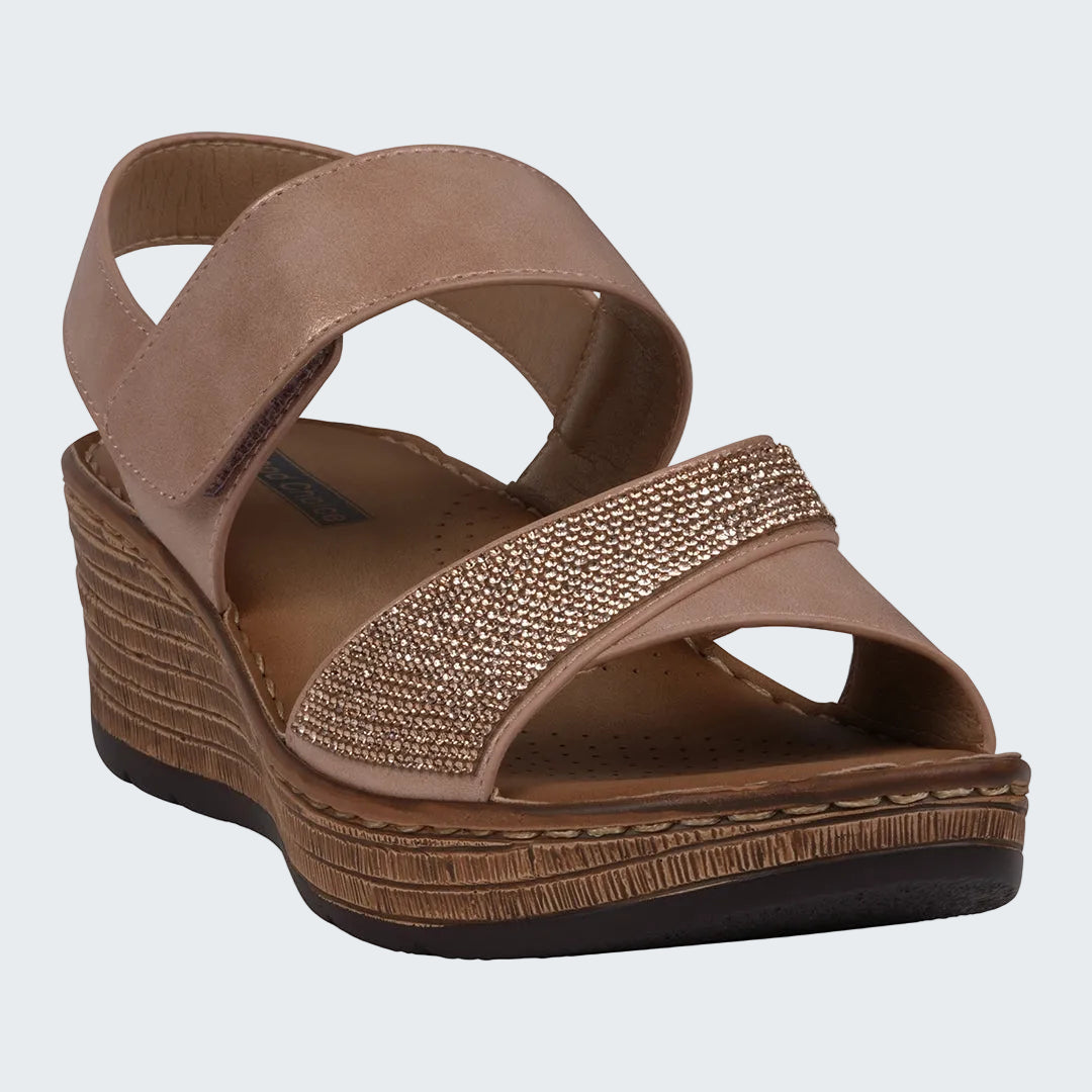 Brown wedge sandal with criss-cross straps and embellished strap on a white background