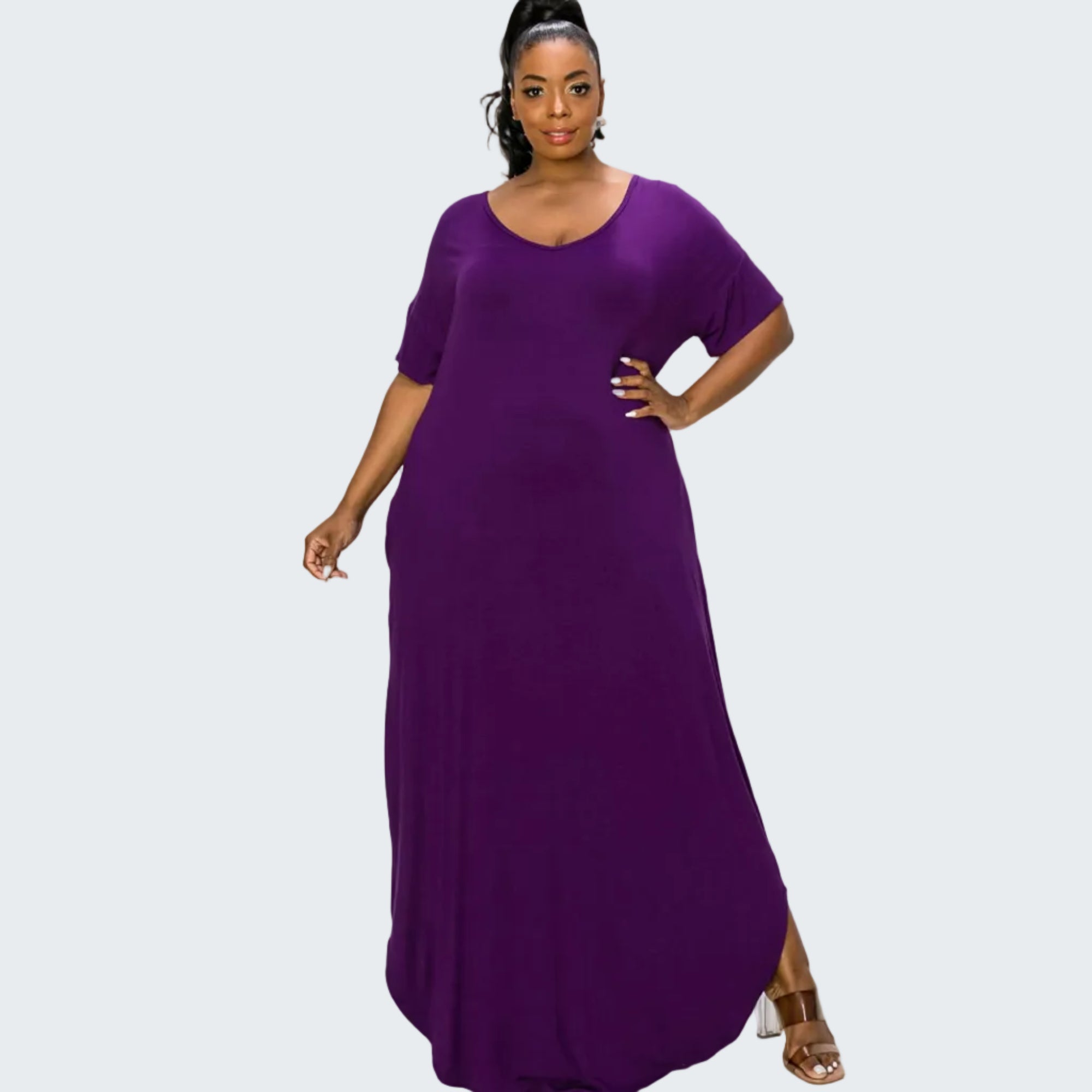A woman modeling a purple short-sleeve maxi dress with a scoop neckline, photographed against a plain white background.