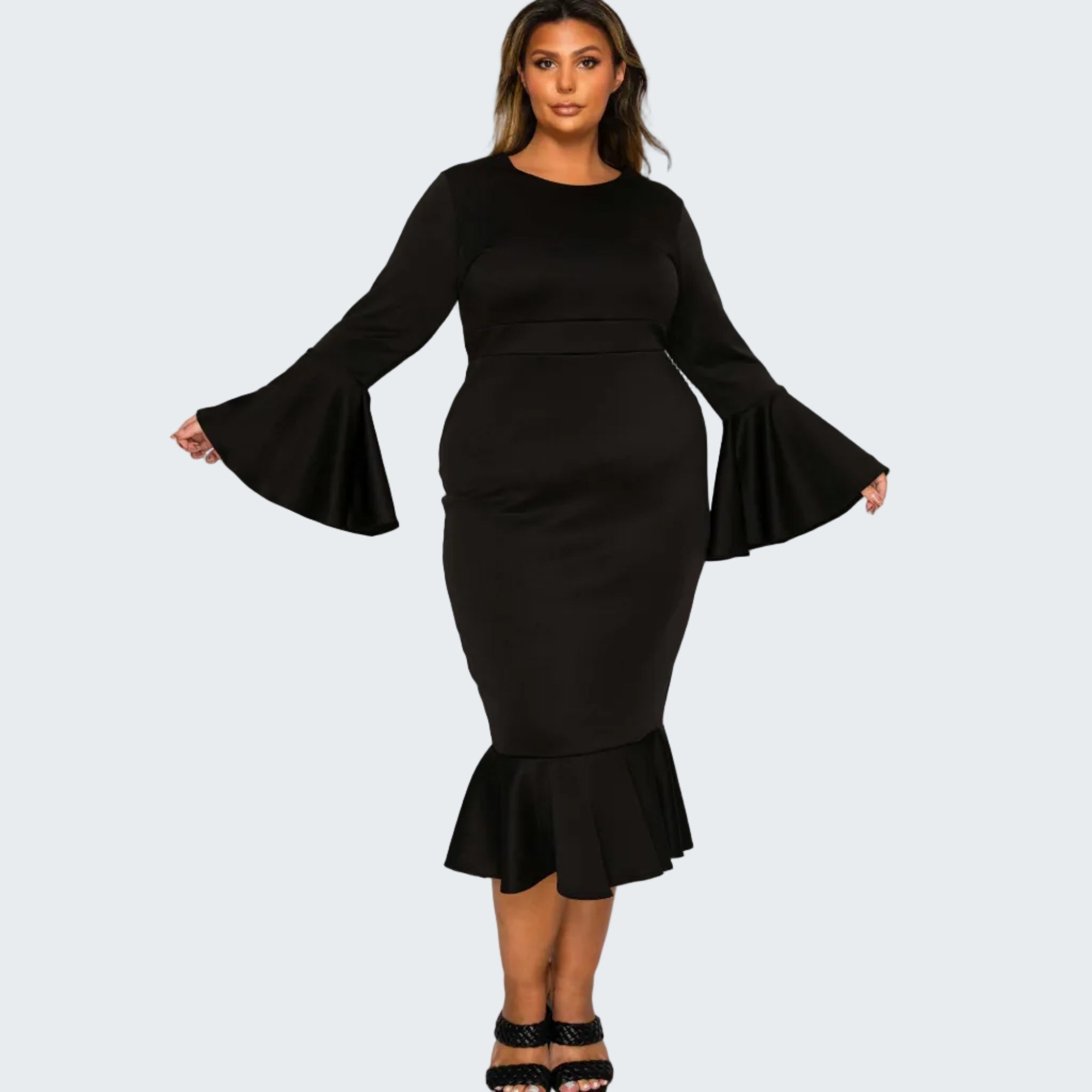 A woman modeling a black long-sleeve midi dress with flared bell sleeves, a fitted waist, and a ruffled hem, paired with black strappy heels against a plain white background.