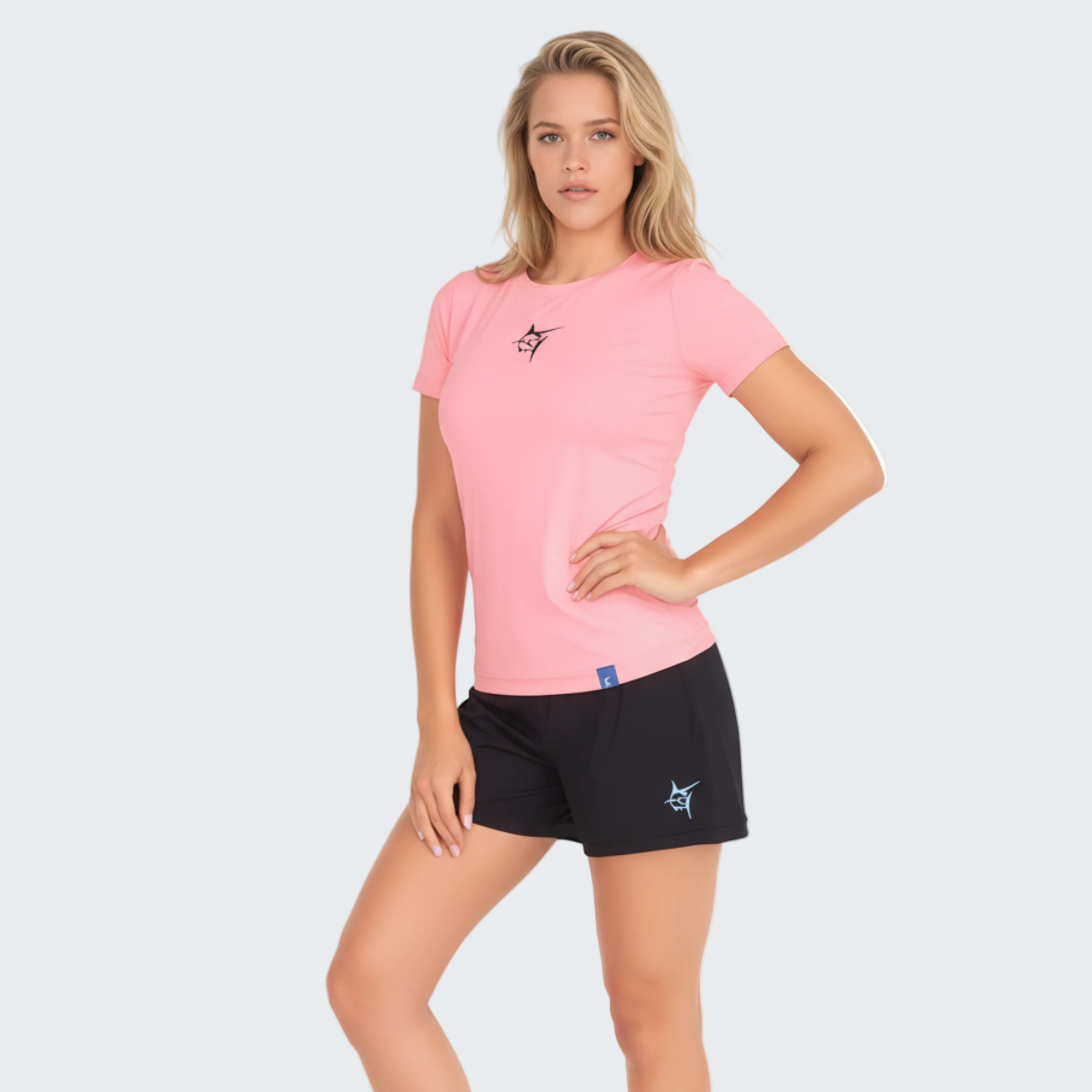 Woman wearing a pink t-shirt and black shorts on a white background