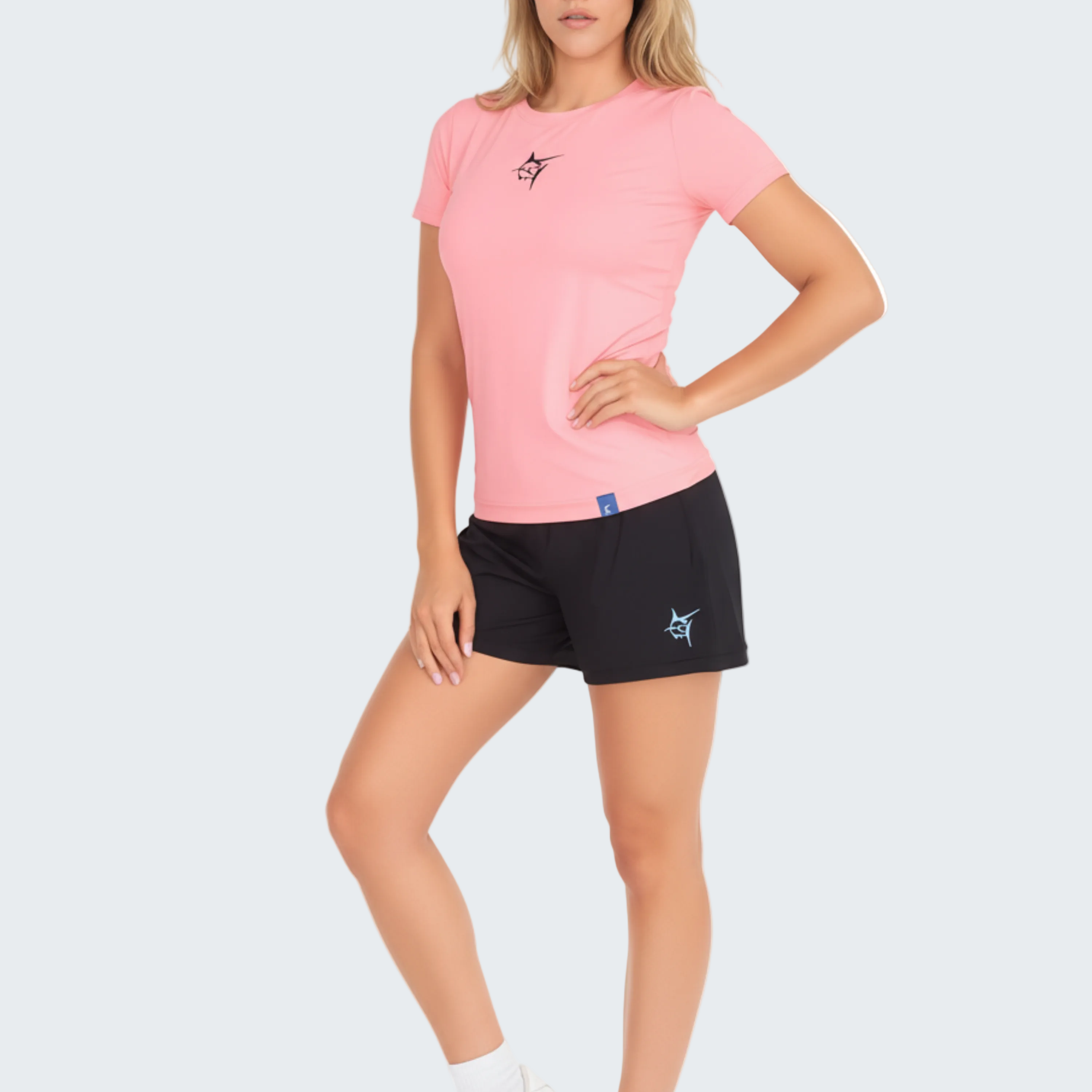 Woman wearing a pink t-shirt and black shorts on a white background