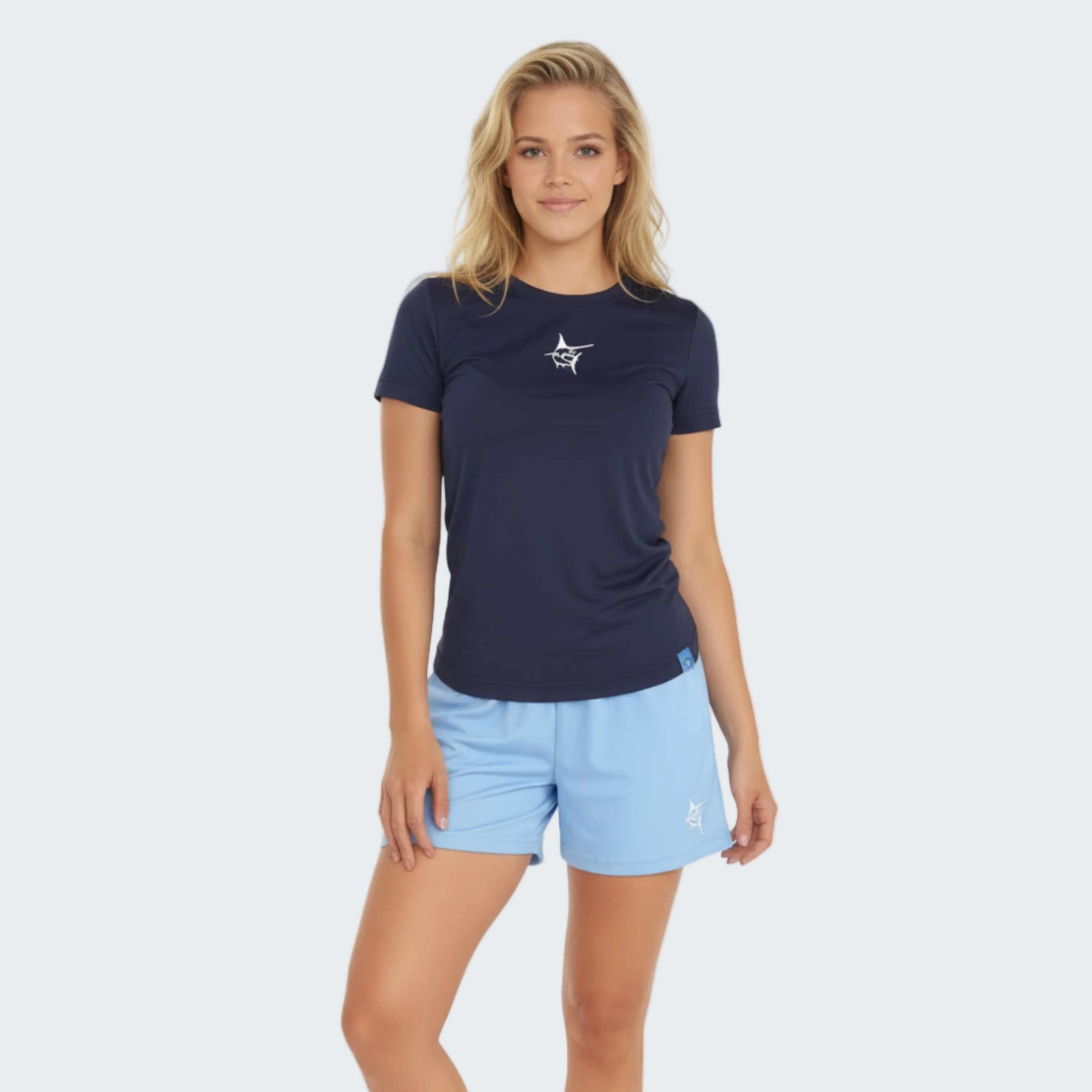 Woman wearing a navy t-shirt and light blue shorts on a white background