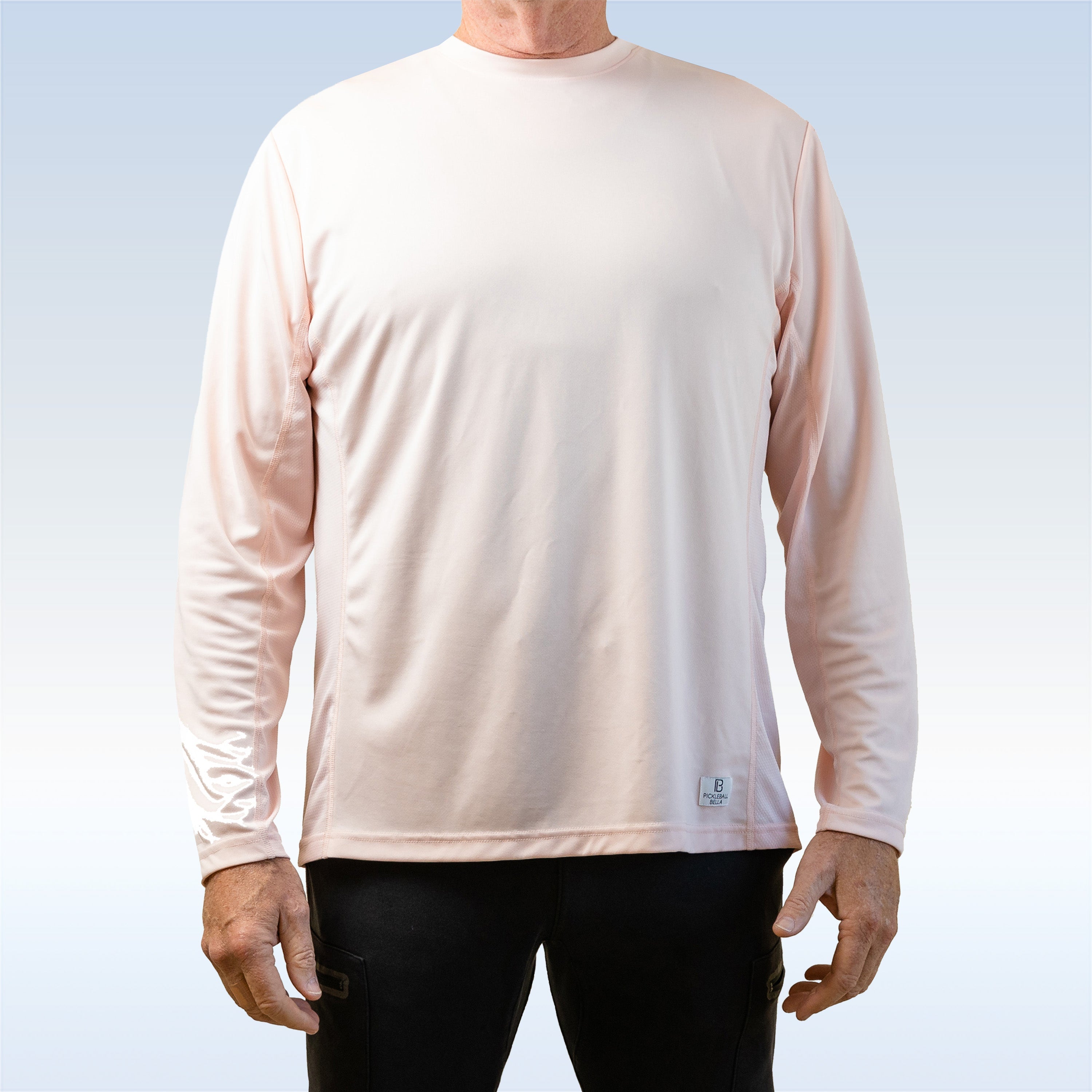 Person wearing a light pink long-sleeve shirt with a small logo on a light blue background