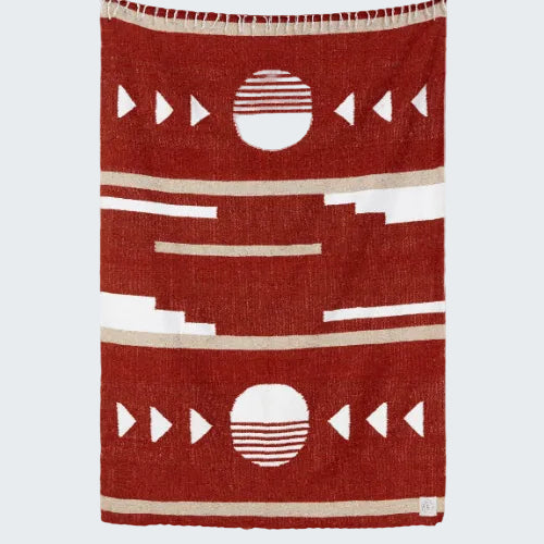 Red blanket with geometric patterns on a white background