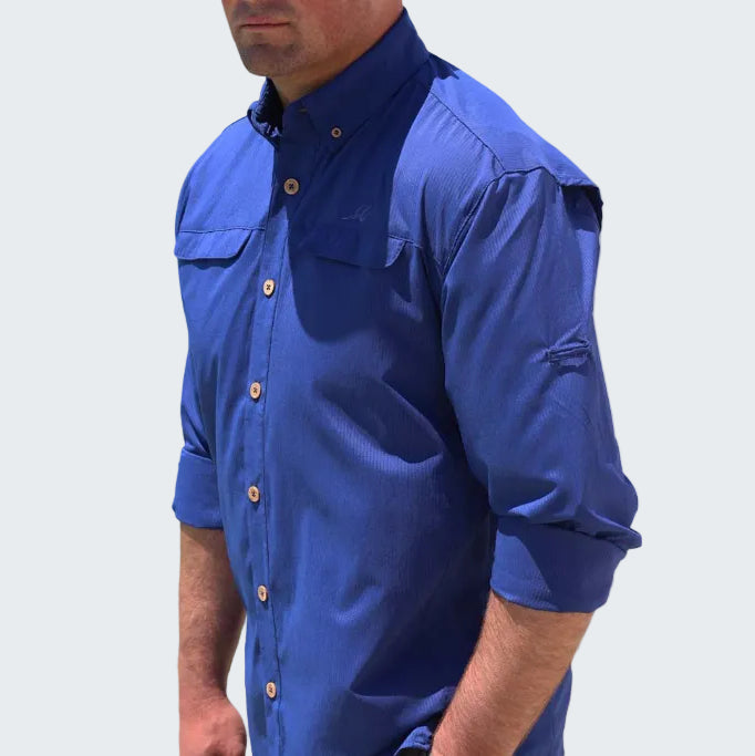 Man wearing a blue shirt with rolled-up sleeves on a white background